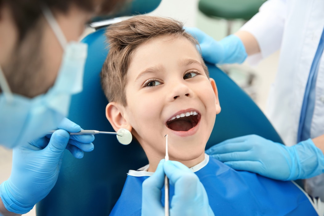dentysta badający zęby dziecka w gabinecie stomatologicznym